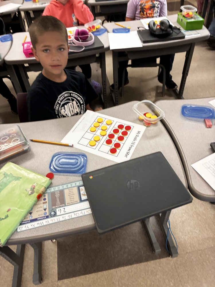 Student work with math double sided math manipulative. 