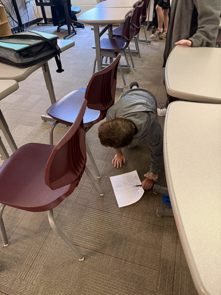 student looking for an answer under a desk.