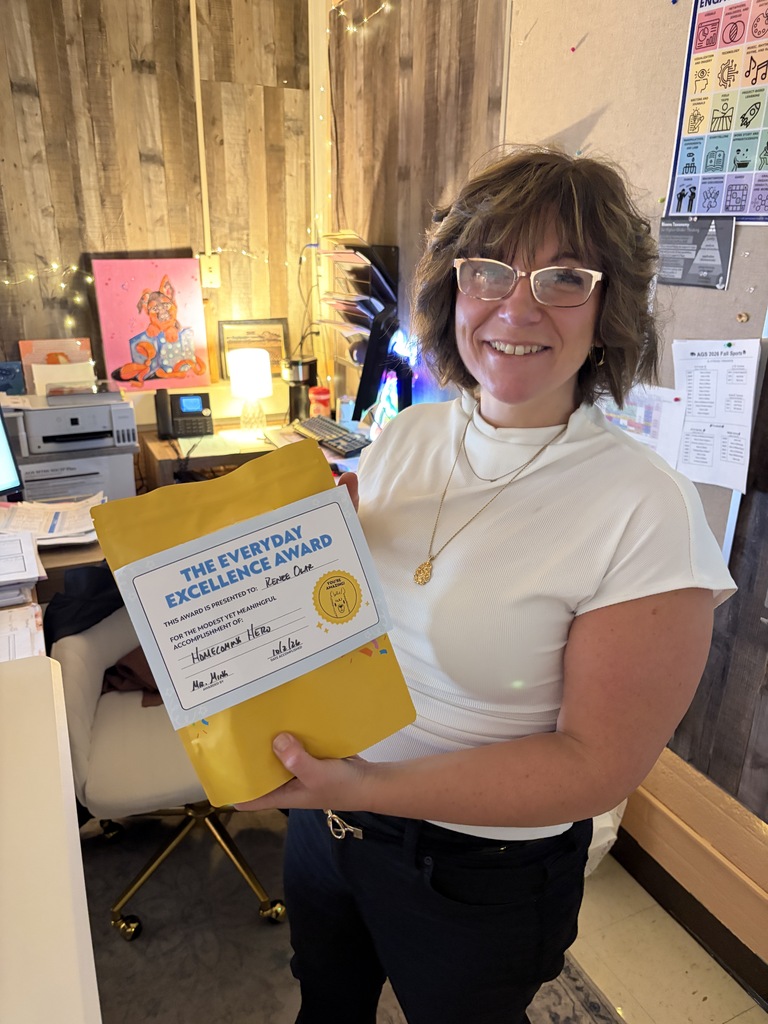 Ms. Olar holding a yellow gift pack.