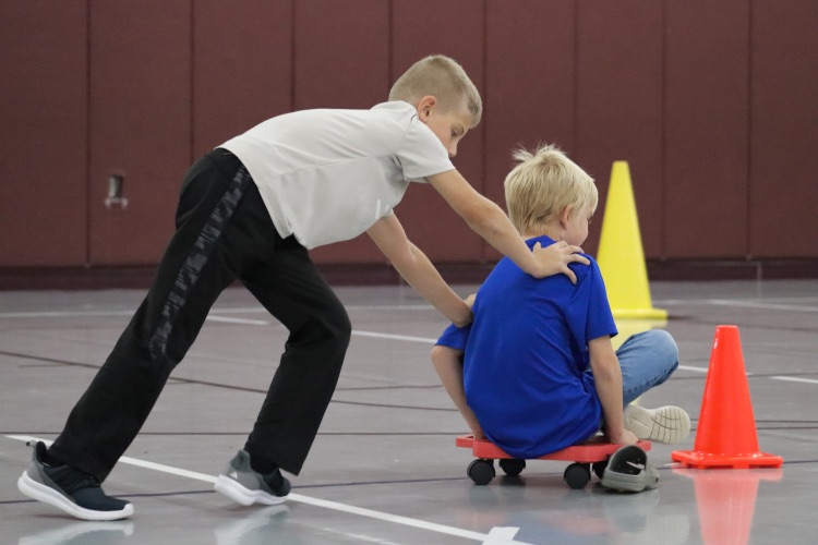 boys pushing each other on scooters