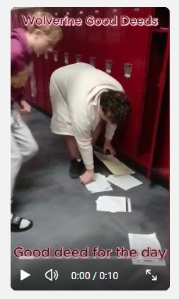 student picking up dropped papers on floor