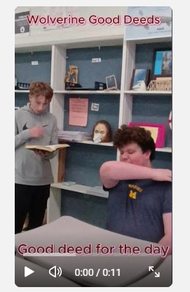 student standing while other student looks at his elbow