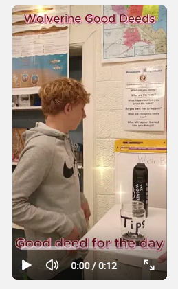 student looking at a poster on the wall