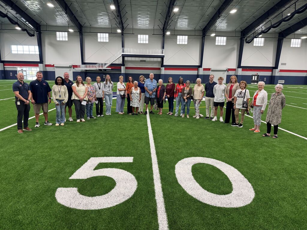 Aubrey ISD Chaparral Legacy Cooperative, residents 60 and up, in group photo on turn in Aubrey High School multipurpose facility