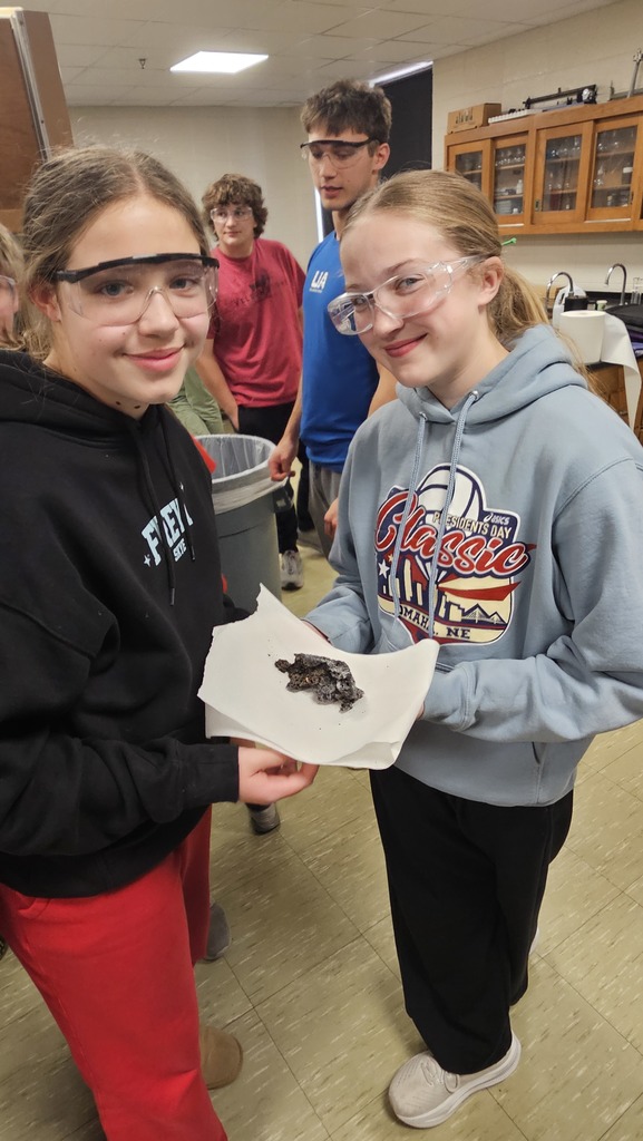 Sixth graders holding the product of a reaction.