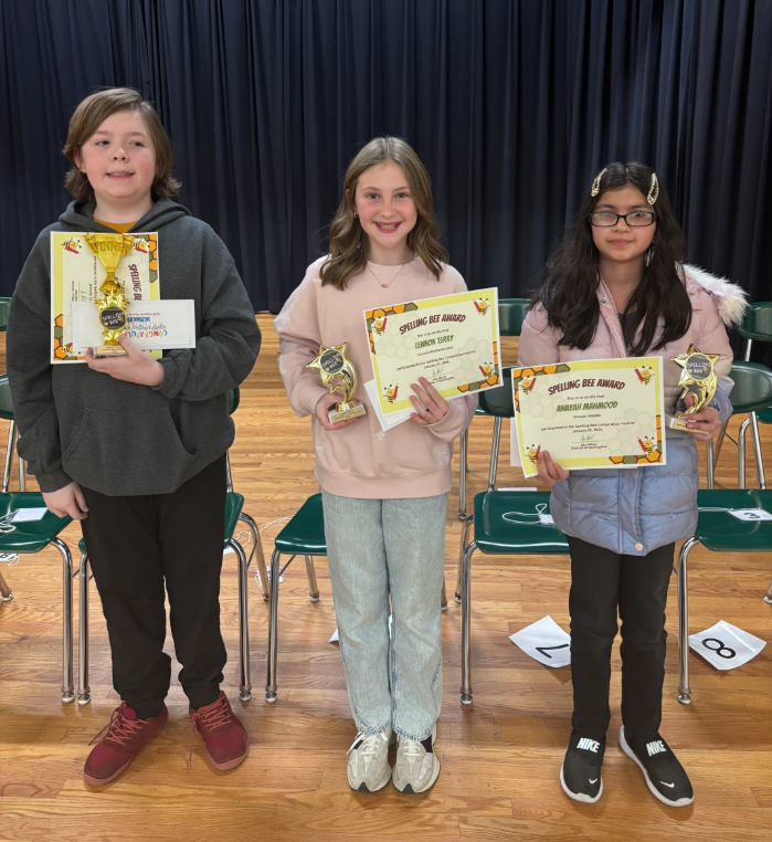Spelling Bee winners standing with their awards