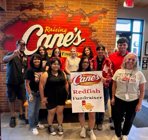 Students, class sponsors, and Raising Cane's manager stand in a group with a fundraiser sign.