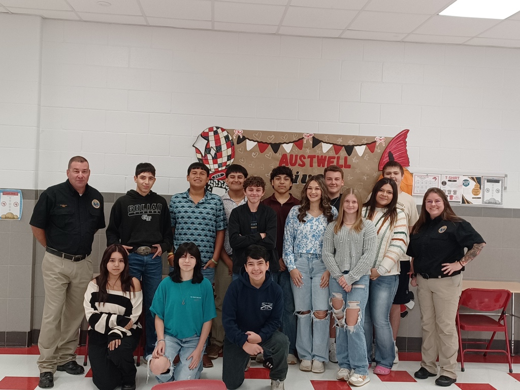 High School students and Victoria Disaster Response Team members pose in front of an Austwell-Tivoli sign.