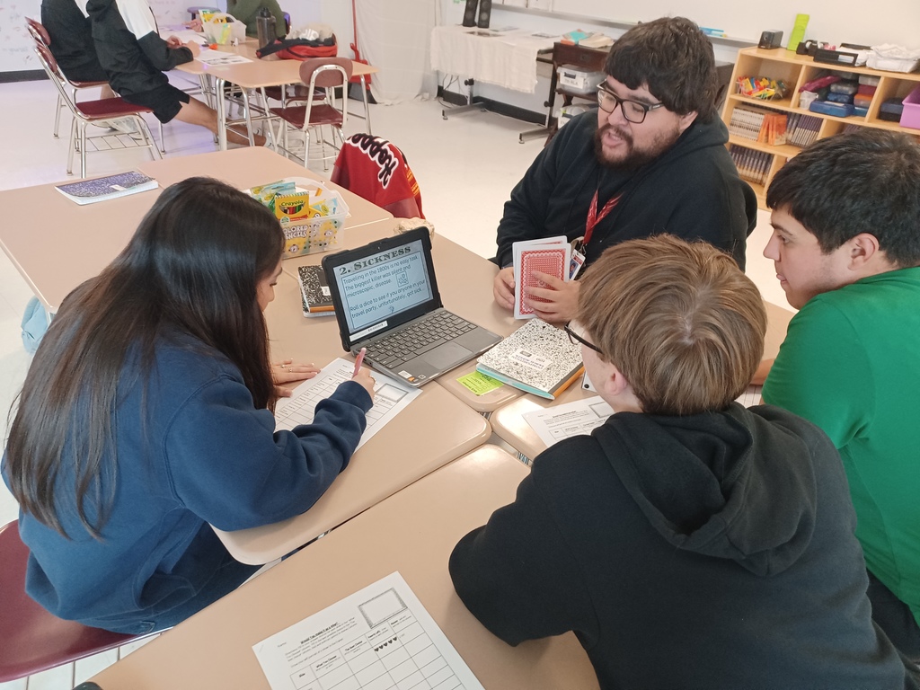 Three students and a teacher work on a simulation game about The Gold Rush.