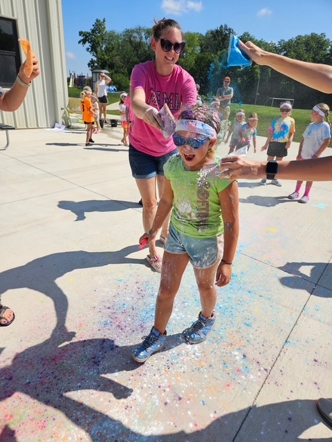 Student getting sprinkled with colored powder