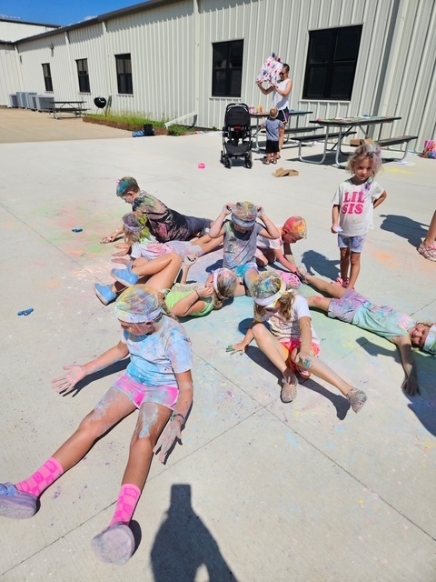 Group of students on ground with colororful powder