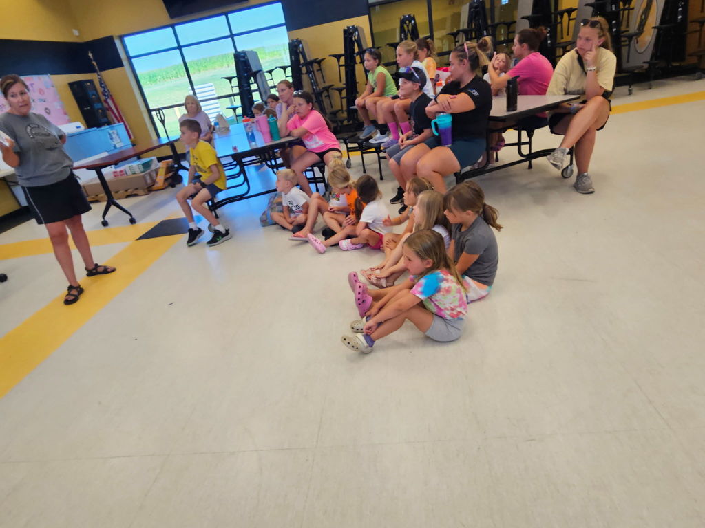 Group of students listening to staff member reading a book
