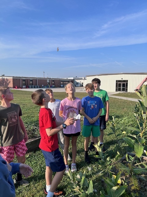 students releasing butterfly