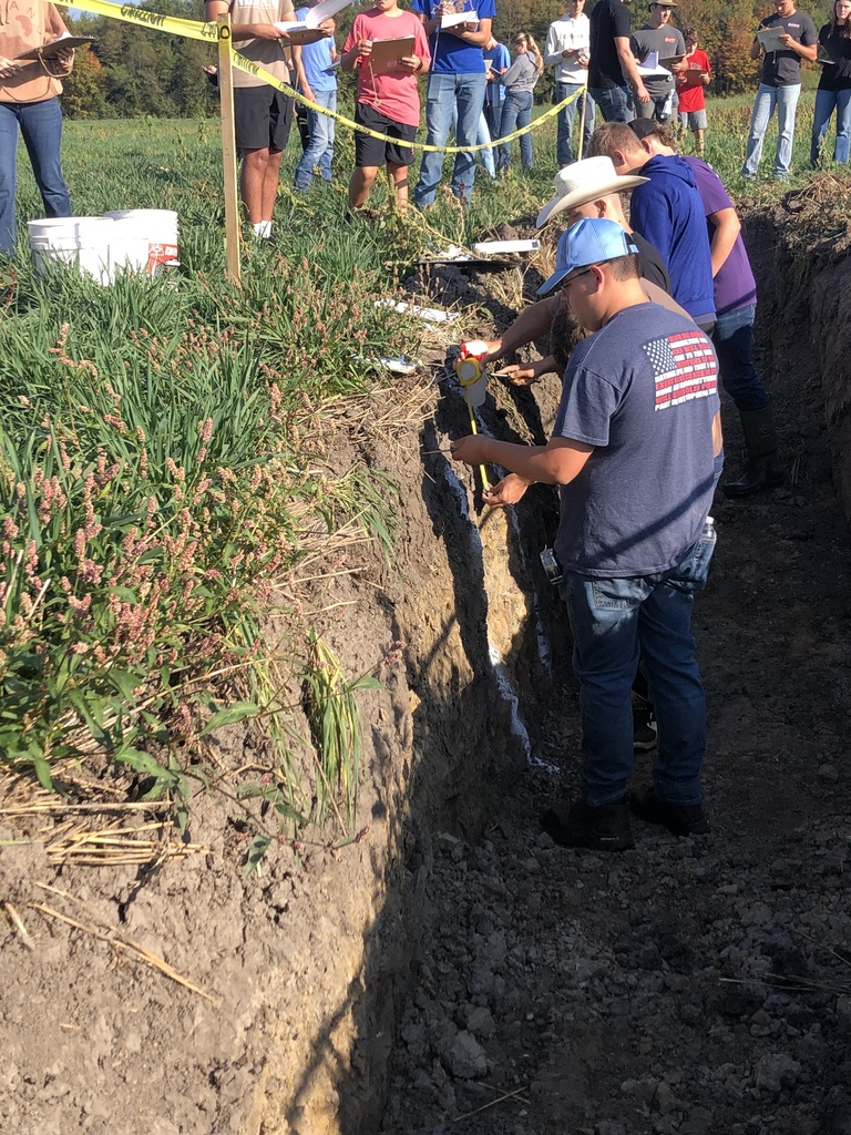 FFA students recording their findings in the hole.