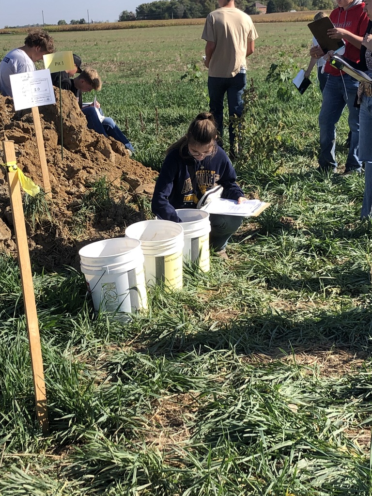 FFA students recording their findings in the hole.