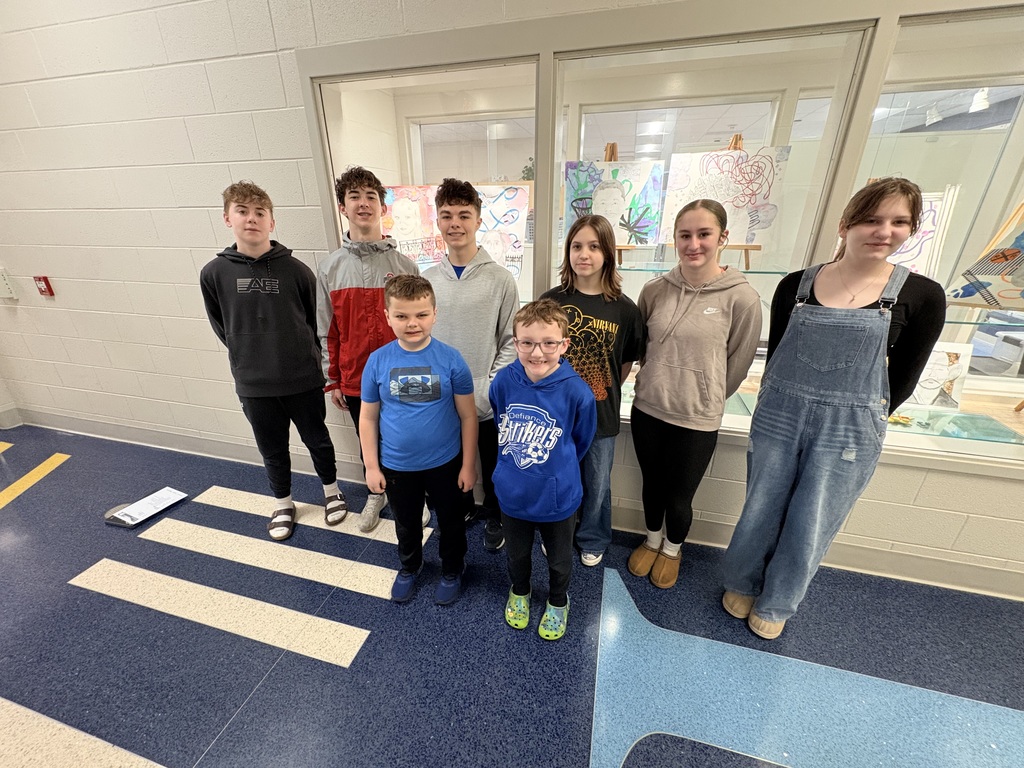 Ayersville student artists featured in the Northwest Ohio Youth Art Month Show. Picture is taken in front of the display case at school.
