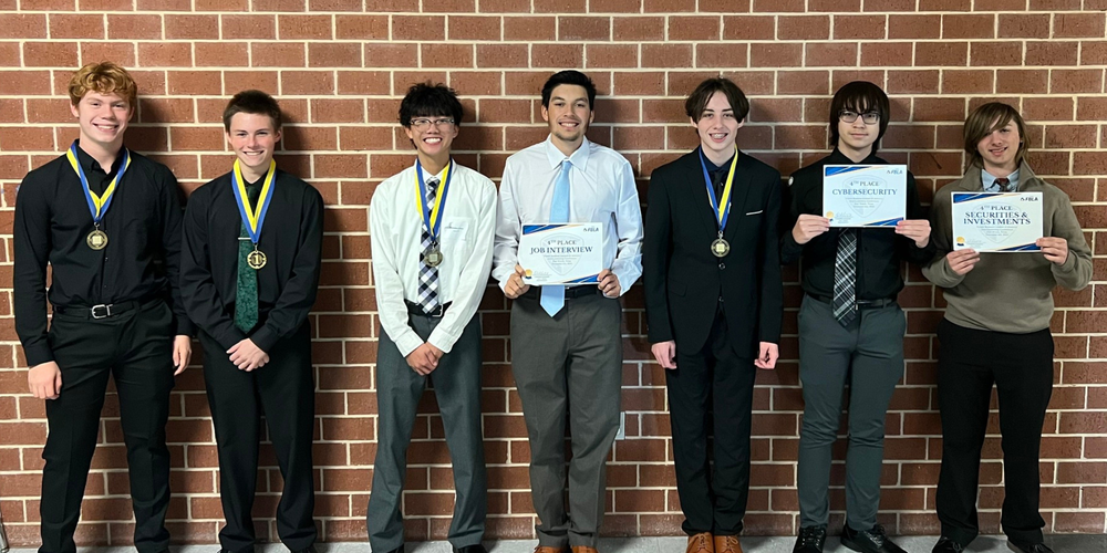 group of male students wearing medals and holding certificates