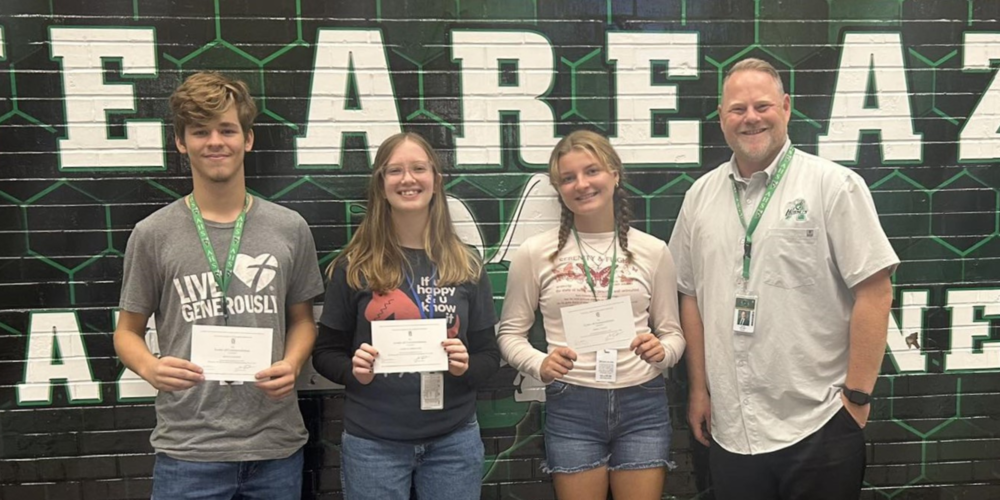 boy and two girls holding certificates with AHS Principal Driver
