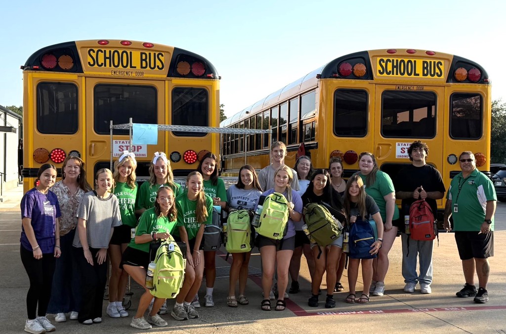 group of students standing in front of two school buses