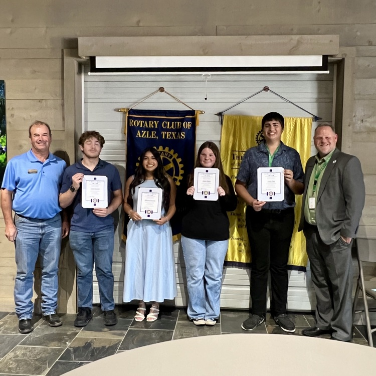 group of students standing in front of Rotary Club banners