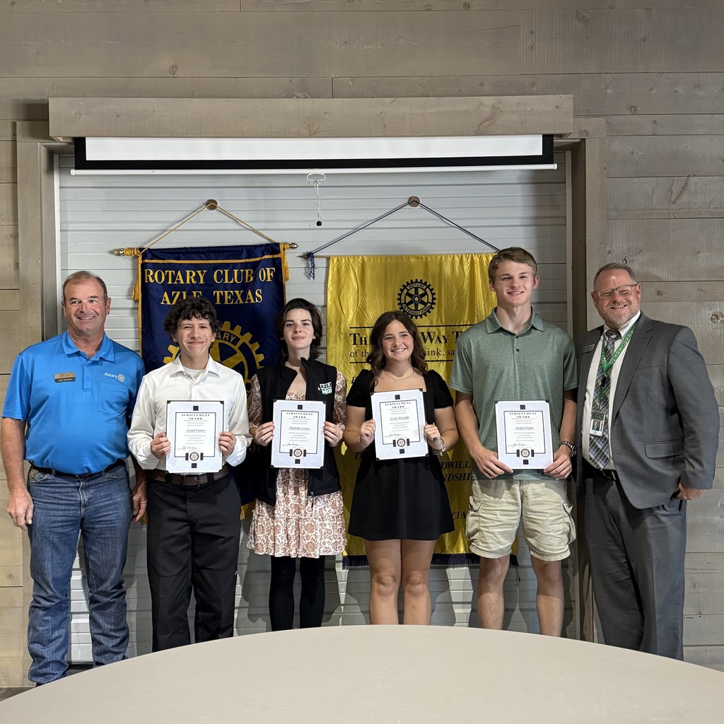 group of students holding certificates, standing in front of Rotary Club banners