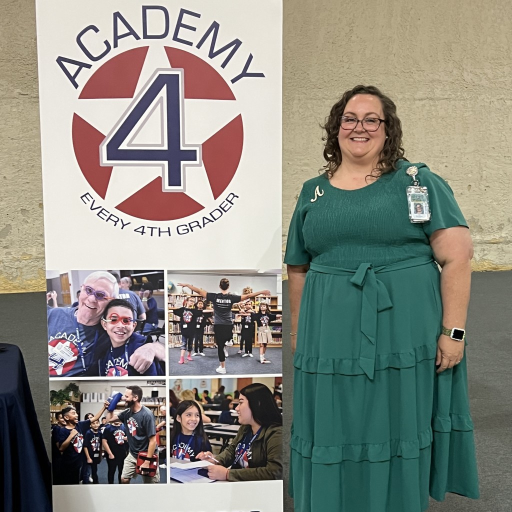 Hilltop Principal Amy Rollmann standing next to Academy 4 pop-up banner