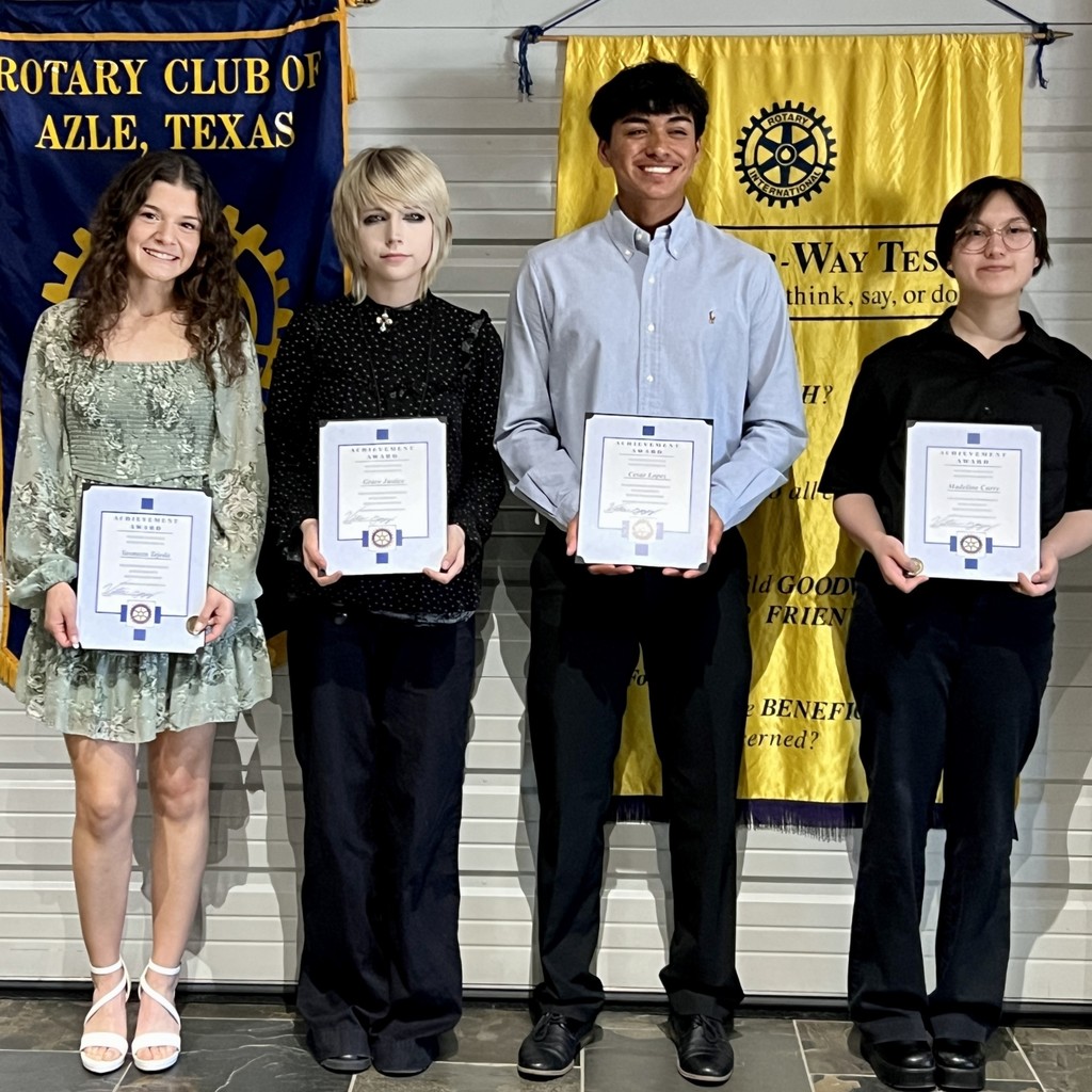 four AHS students holding certificates, standing in front of Rotary Club banners