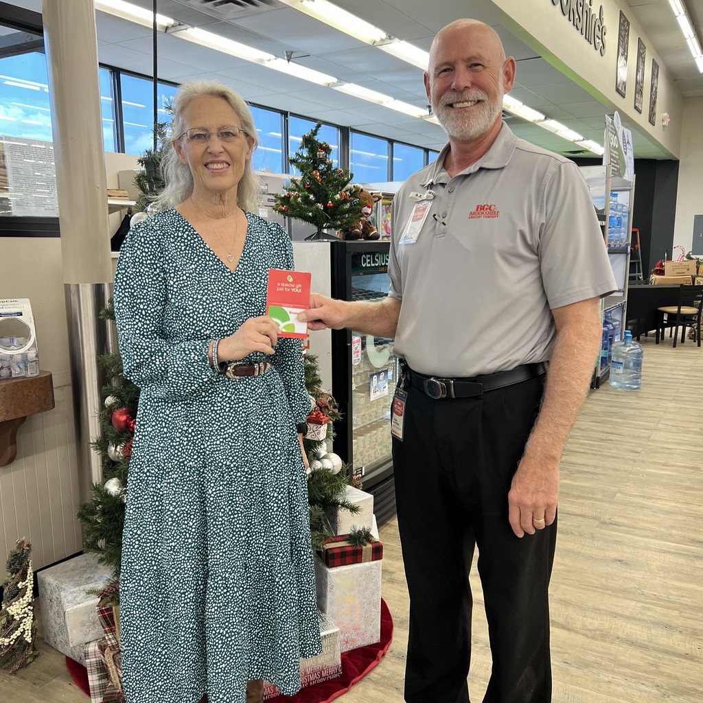 AJH teacher Jennifer Corbin holding gift card with Brookshire's store manager
