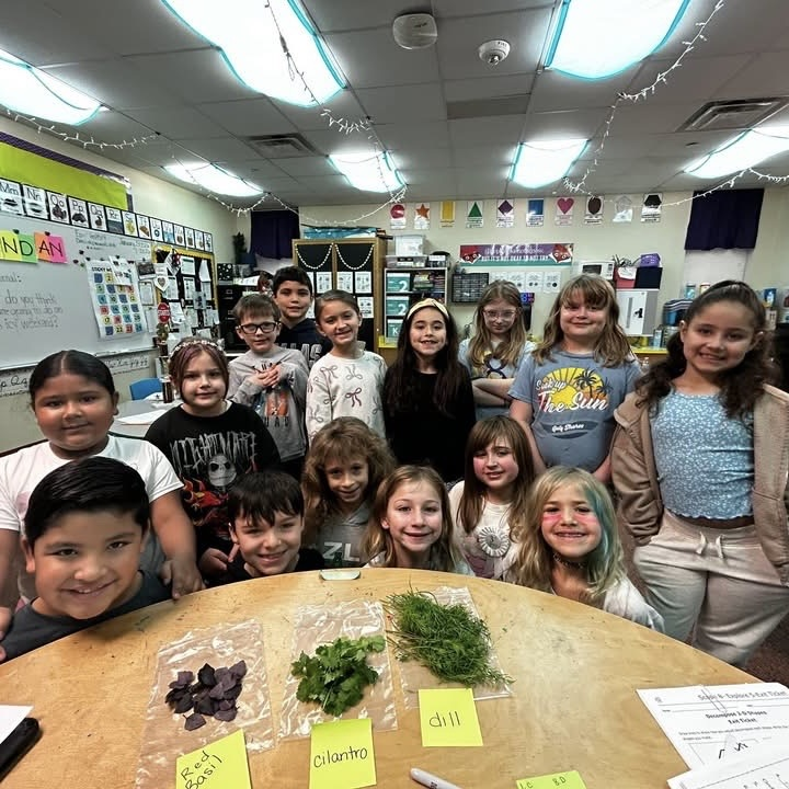 group of elementary students in classroom with vegetables on table 
