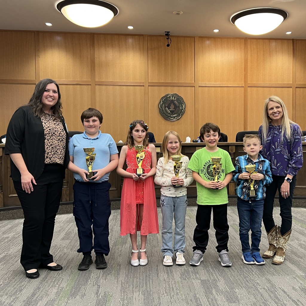 elementary students holding science fair trophies