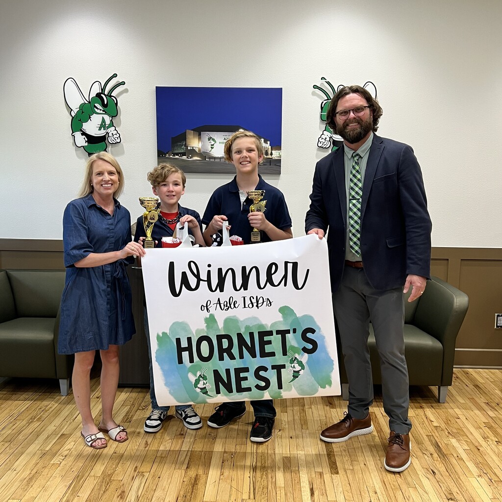 group of students holding trophy and banner that reads "Winner of Azle ISD's Hornet's Nest"
