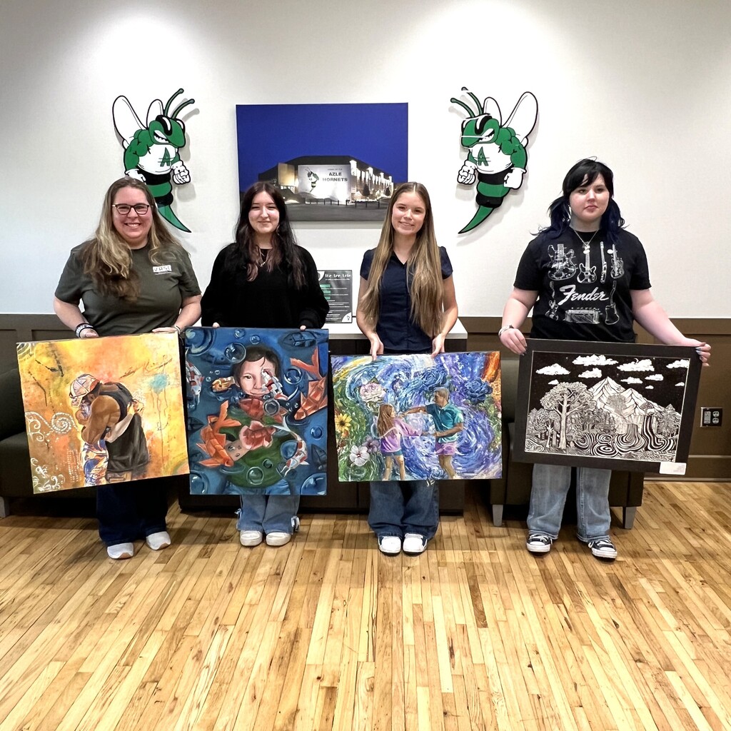 group of students holding paintings