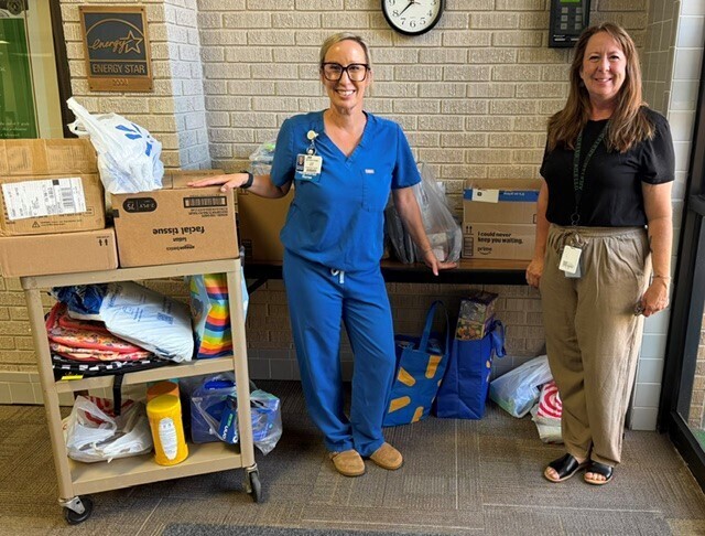 two ladies standing with cart full of school supplies