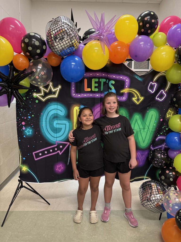 Photo of students in front of Let's GLOW Crazy backdrop
