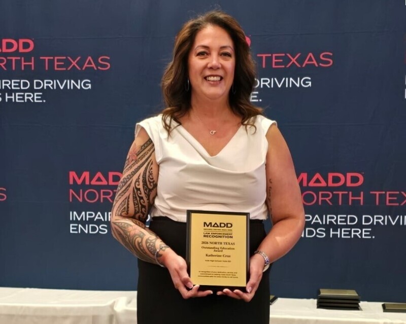 AHS teacher Katherine Cruz holding a plaque in front of a MADD backdrop