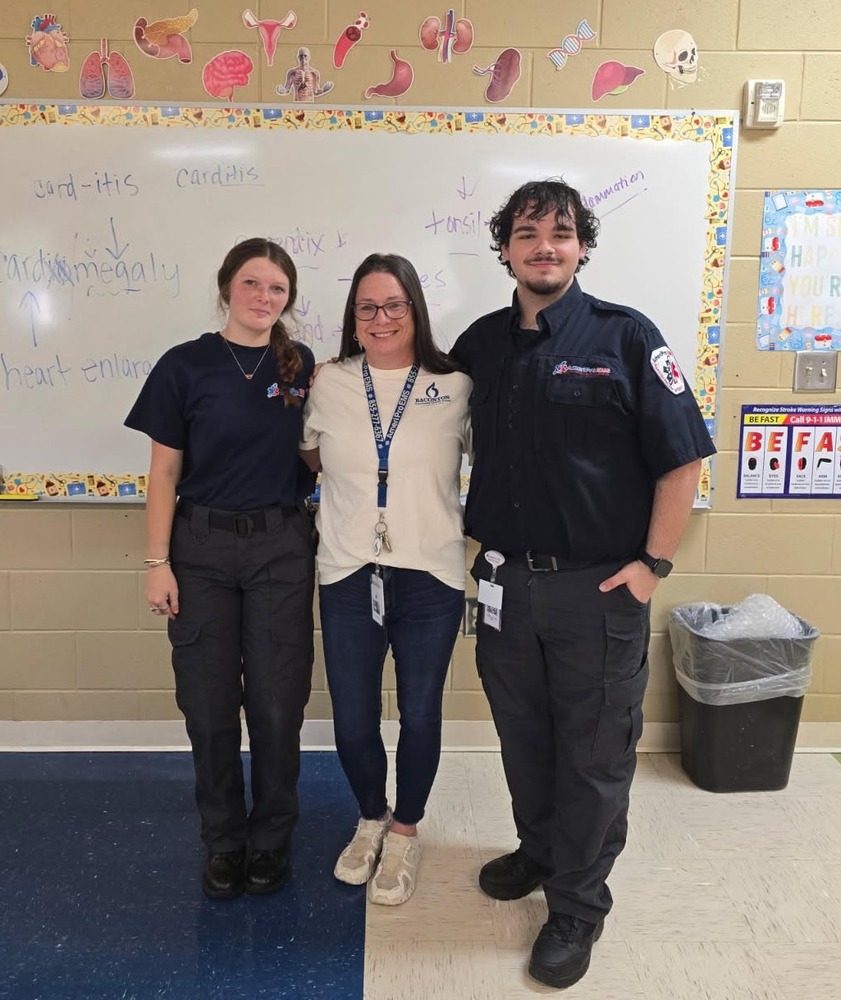 EMTs flank their former teacher