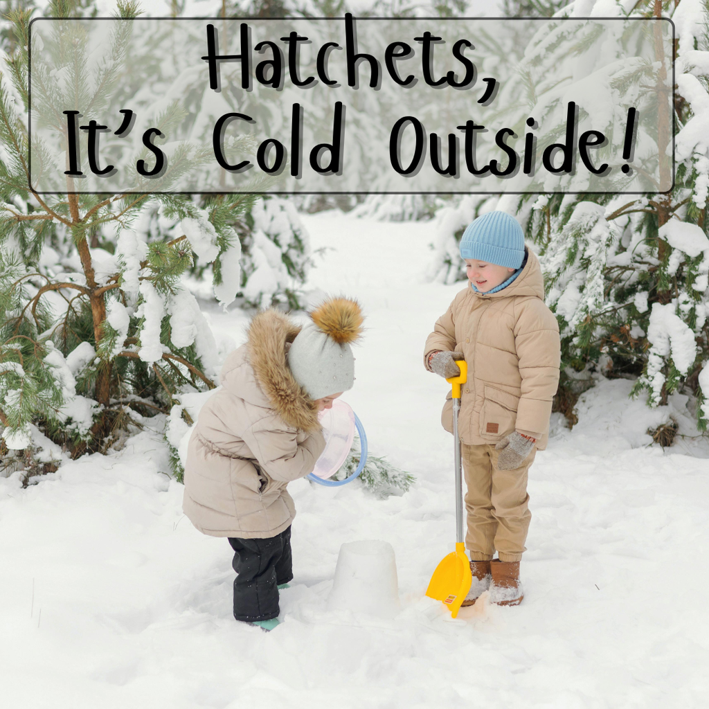 Two young children building a snow castle in the snow with evergreen trees behind them.