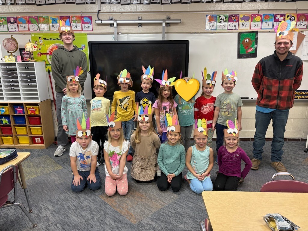 Mrs. Stapleton's Kindergarten class with turkey hats standing next to High School FFA students.