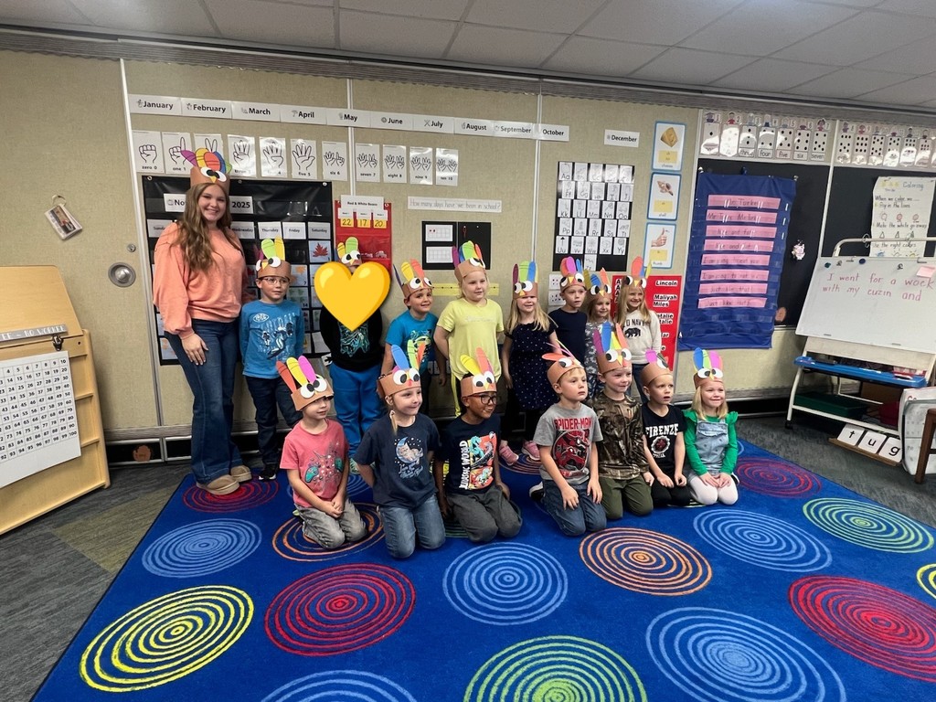 Mrs. Maurer's Kindergarten class with turkey hats standing next to High School FFA students.