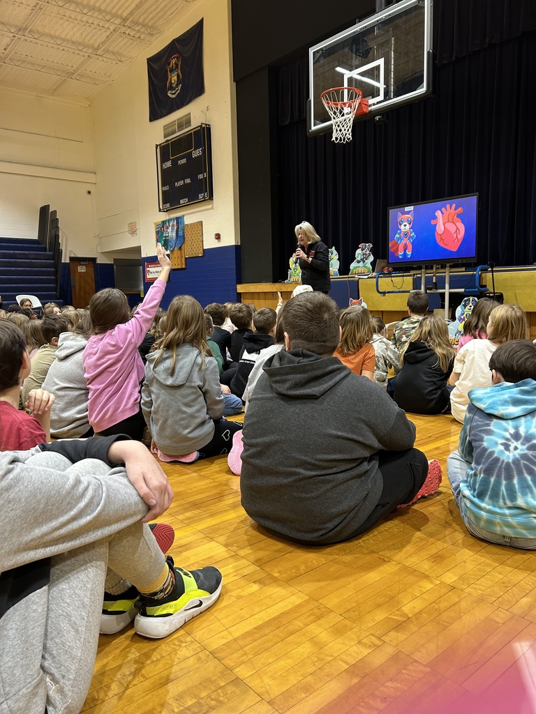 Students at Bad Axe Middle School sit crisscross in the gym for a Kids Heart Challenge Presentation. 