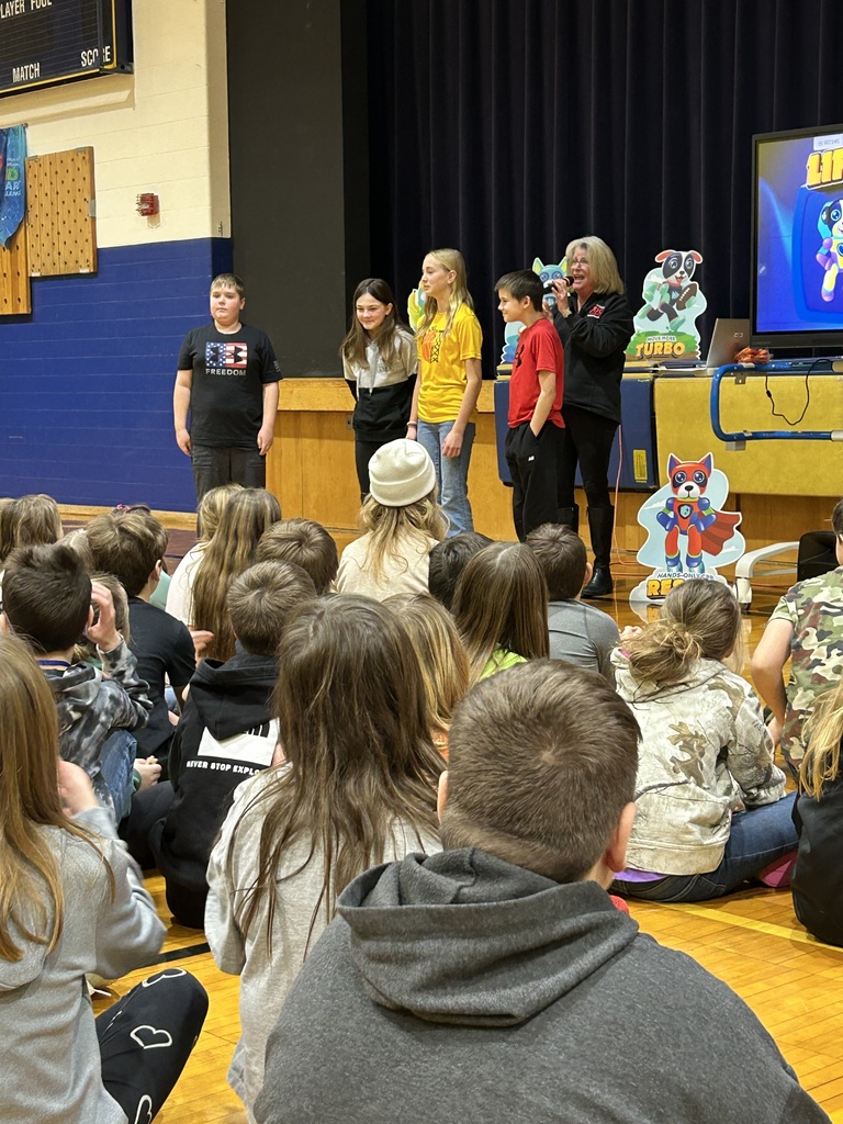 Students at Bad Axe Middle School sit crisscross in the gym for a Kids Heart Challenge Presentation. 