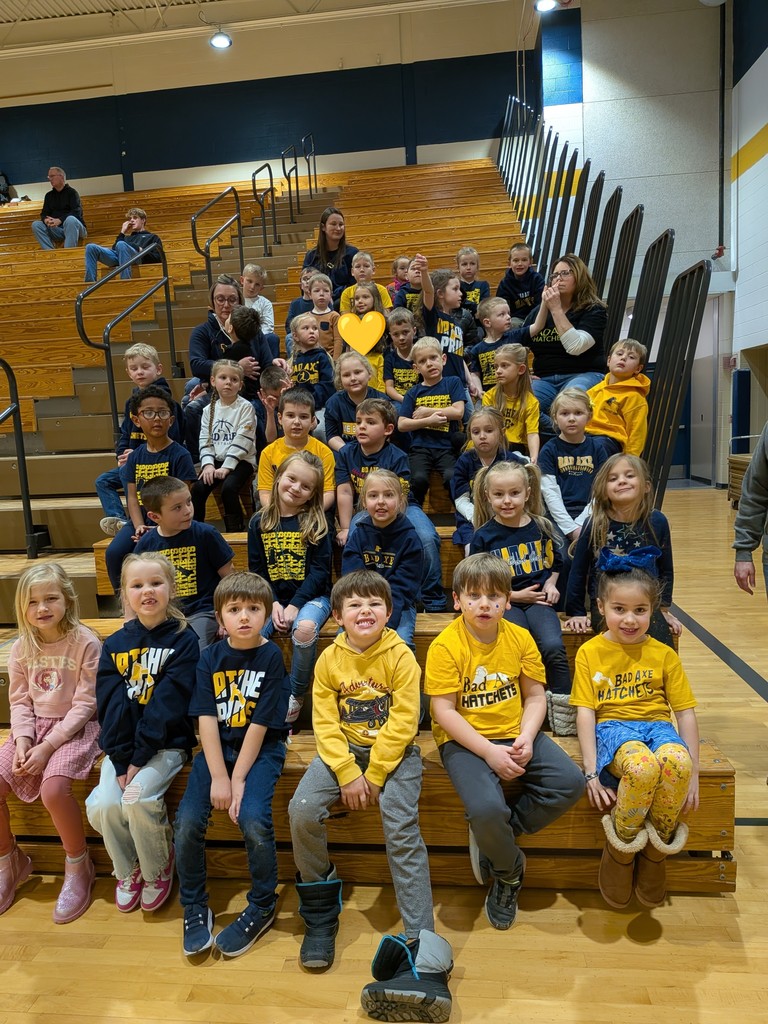 Kindergarteners sitting in the bleachers waiting for their performance. 