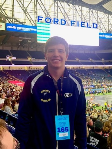 Grant Smith standing in front of the billboard at Ford Field