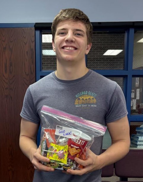Grant Smith holding goodie bag for state wrestling. 