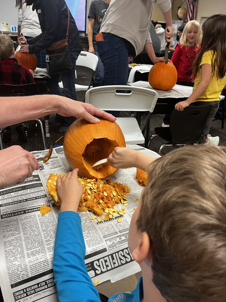 student cleaning a pumpkin