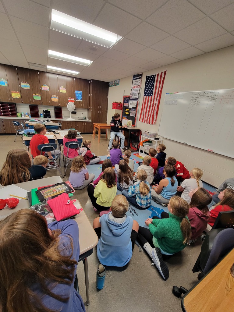 Football players reading to students