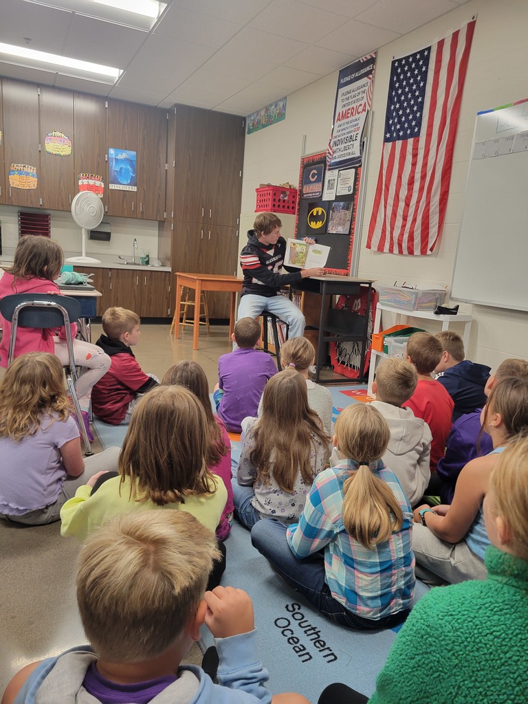 Football players reading to students