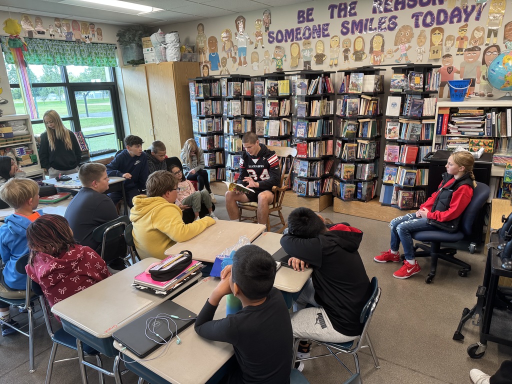 Football players reading to students