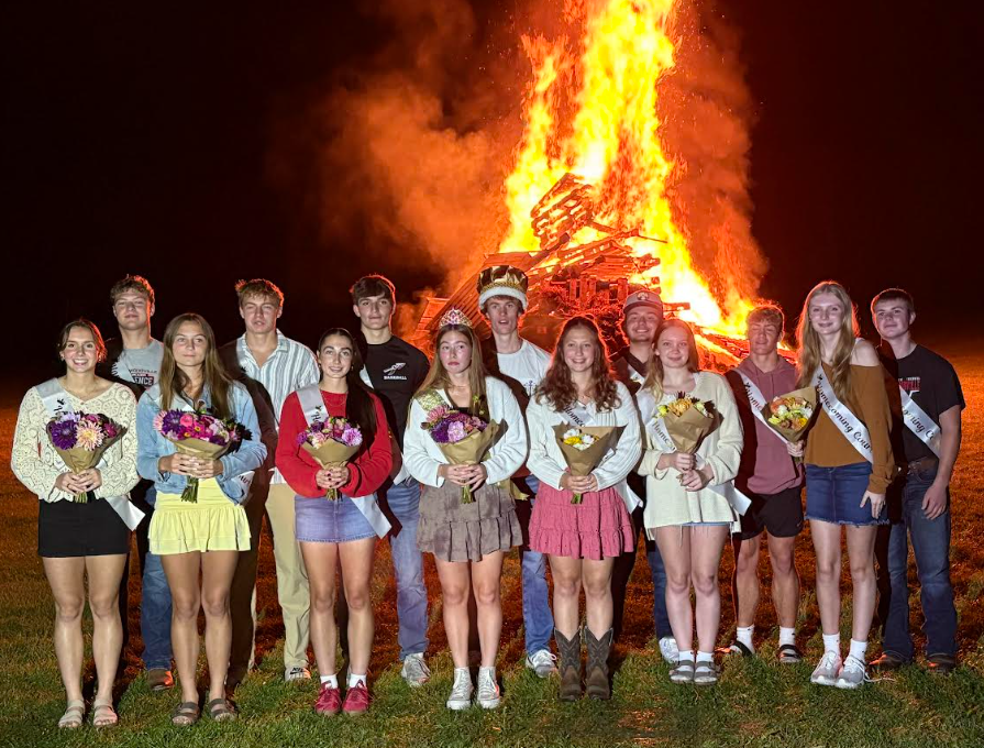 Homecoming Court 2025 in front of bonfire