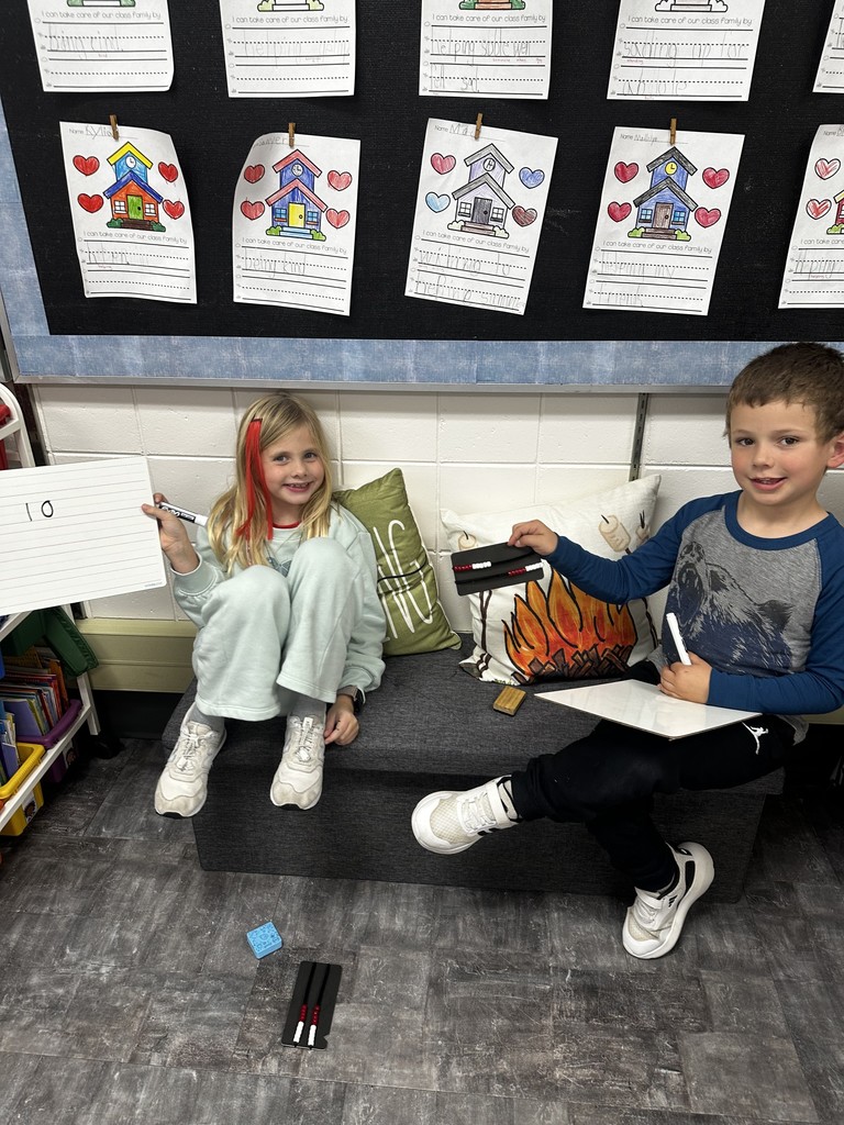 Students smiling on a bench with their math activity.